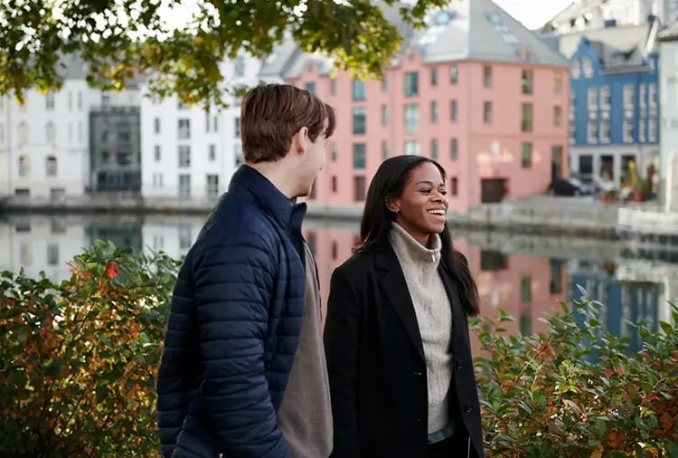 En tjej och kille som går och pratar med varandra