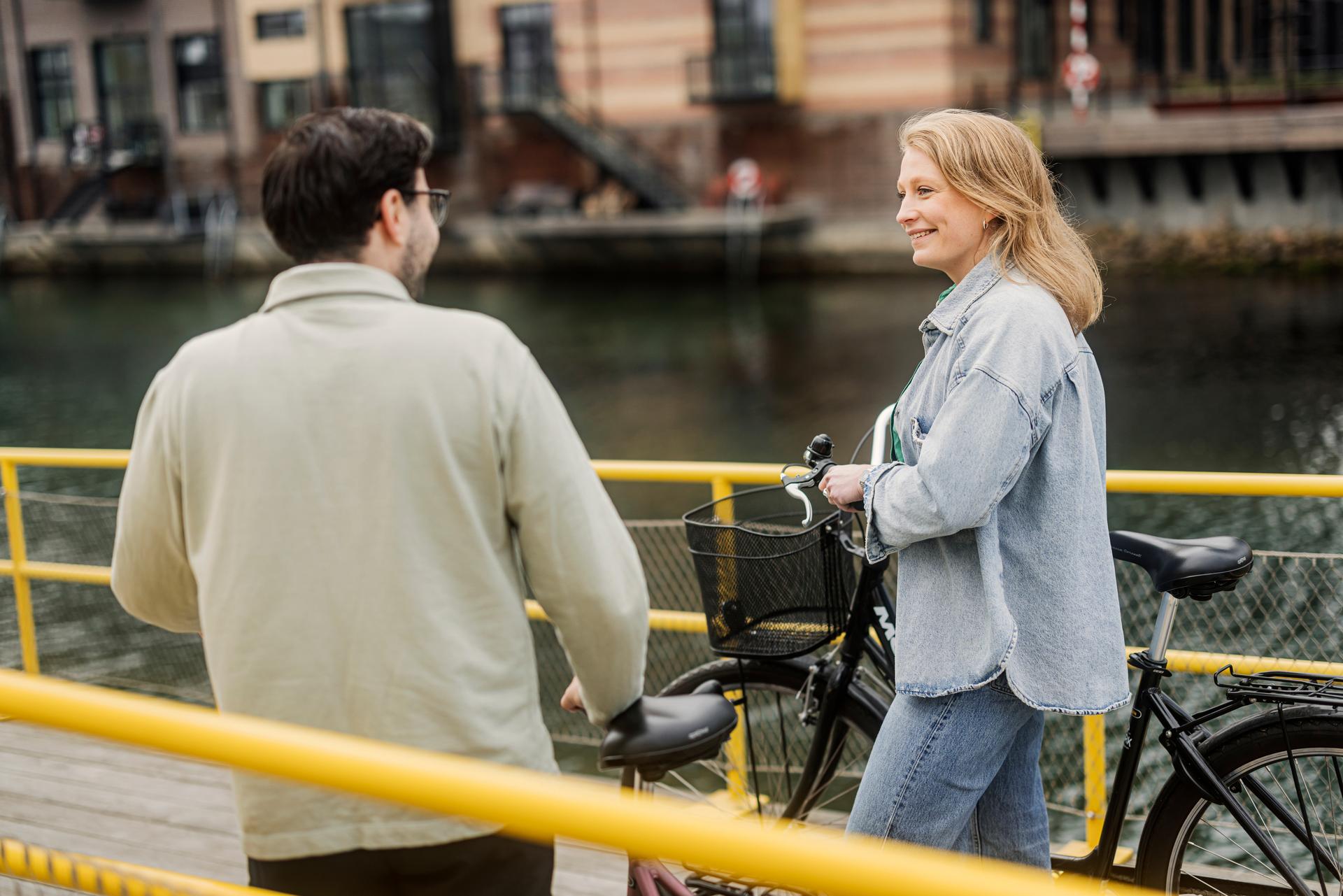 Tjej och kille som går med en cykel