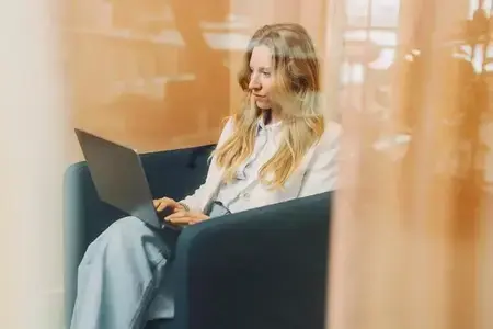 Kvinna som sitter med en dator