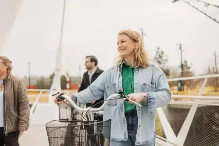 Tjej som går med en cykel